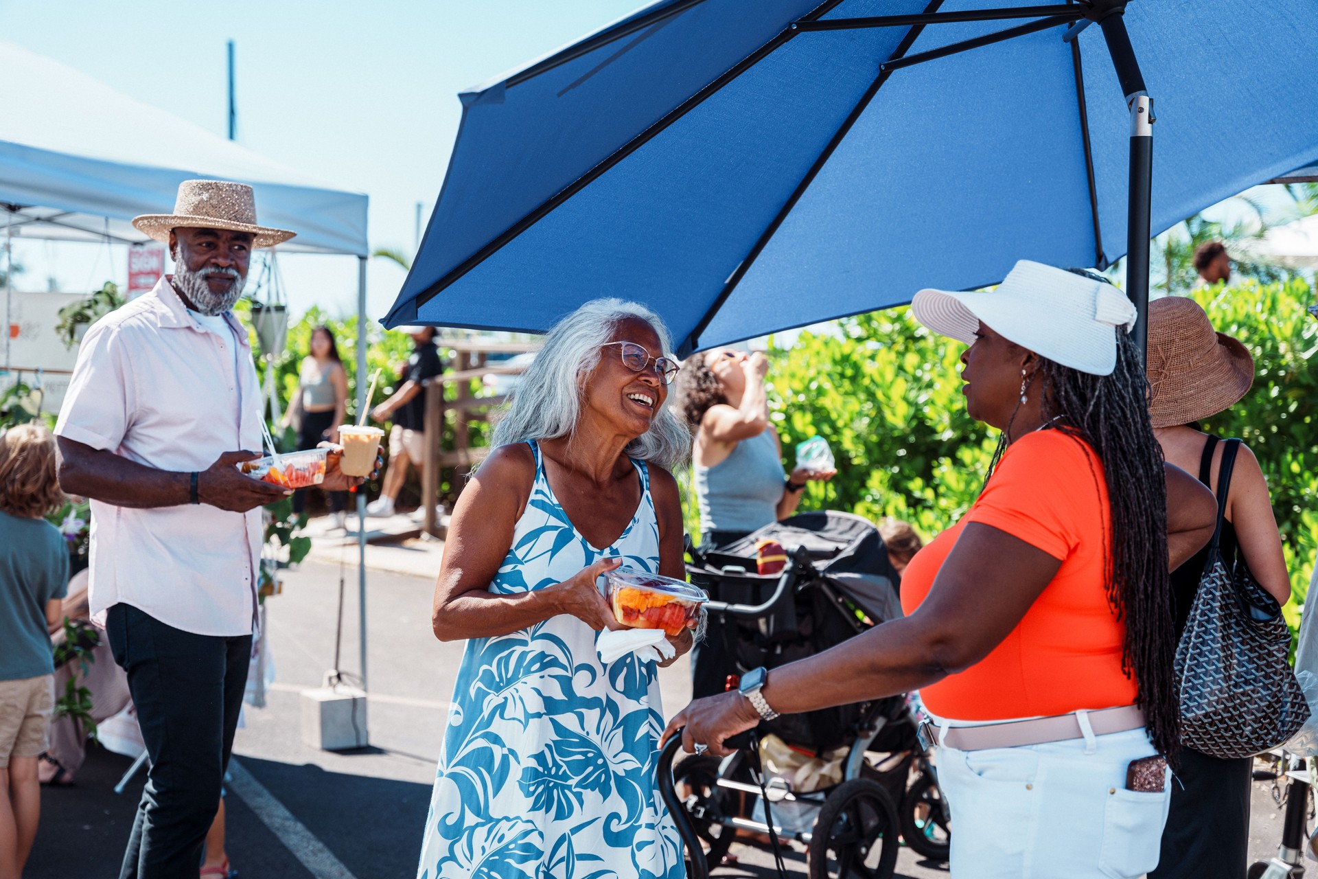 Hawaiian tour guide talking with African American tourists at street market Hawaiian tour guide talking with African American tourists at street market
